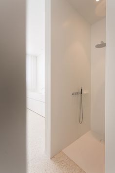 an empty bathroom with a shower head and hand held shower faucet in the corner