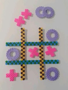 the beads are arranged in different colors and shapes to make a tic - tac - toe game