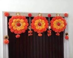 an orange and yellow flower decoration hanging from a window