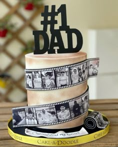 a birthday cake decorated with film strips and the number one dad topper on it