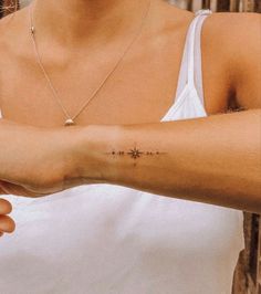 a woman with a cross tattoo on her arm