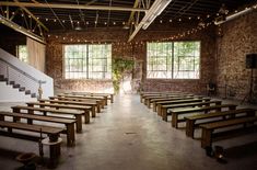 an empty room with wooden benches and string lights