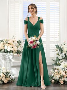 a woman in a green bridesmaid dress standing next to flowers