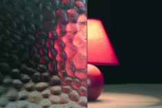 a red lamp sitting on top of a table next to a glass window covered in bubbles