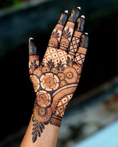 a woman's hand is decorated with hennap and flower designs on it