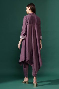 Purple full sleeves asymmetric hem tunic kurta in cotton silk base with blossom embroidered cuff using tonal beads, sequins. Paired with matching draped pant.
Components: 2
Pattern: Embroidery
Type Of Work: Flora Beads, Sequins
Neckline: Collar
Sleeve Type: Full
Fabric: Cotton Silk
Color: Purple
Occasion: Sangeet, Mehendi and Haldi - Aza Fashions Eid Embroidered Kurta With Asymmetrical Hem, Embroidered Asymmetrical Hem Kurta For Eid, Festive Anarkali Kurta With Asymmetrical Hem, Designer Asymmetrical Hem Kurta For Eid, Designer Kurta With Asymmetrical Hem For Eid, Embellished Cotton Kurta For Eid, Festive Embellished Cotton Kurta, Drape Pants, Pant For Women