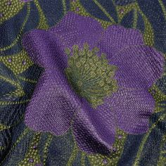 purple and green fabric with flowers on the bottom, as well as an image of leaves