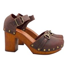 CLOGS HANDMADE IN ITALY Dutch style clogs with brown wood effect base Brown upper with golden accessory Closed rounded tip Adjustable ankle strap Padded leather insole Heel height 9cm with 2.5cm plateau Entirely made by specialized Italian personnel Handcrafted using the best materials. BEFORE COMPLETING YOUR PURCHASE DO NOT FORGET TO CHECK THE SIZE! Wooden Clogs With Stacked Heel And Round Toe, Brown Sandals With Brass Buckle, Brown Clogs With Wooden Block Heel, Wooden Round Toe Heels With Stacked Heel, Brown Wooden Block Heel Sandals, Brown Clogs With Heel Loop And Ankle Strap, Brown Clogs With Heel Strap And Round Toe, Brown Clogs With Stacked Heel And Ankle Strap, Wooden Stacked Heel Round Toe Heels