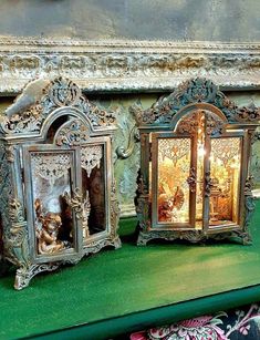 two ornate mirrors sitting on top of a green shelf next to a candle holder with an angel figurine in it