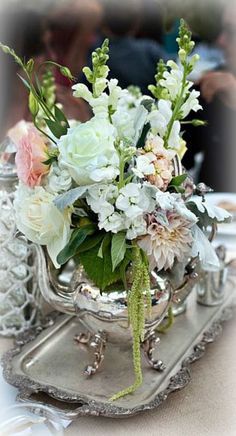 a vase filled with flowers on top of a silver tray