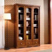 a wooden bookcase sitting in the corner of a living room next to a lamp