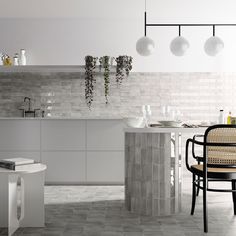 a modern kitchen with white and grey tiles