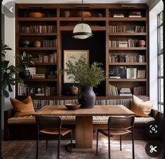 a dining room table and chairs with bookshelves in the background