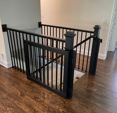 an empty room with wooden floors and black railings