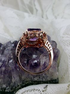 Natural Purple Amethyst Rose Gold plated Sterling Silver RingPicture Frame Design#D227 Inspired by Victorian era designs, this is a lovely reproduction ring. This lovely filigree handcrafted sterling silver ring is overlaid with rose gold plating. This flawless 5 carat Natural Purple Amethyst is 11mm x 9mm. The ring is 11/16" (17.5mm) North to South on the finger. The inside of the band is marked 925 for sterling silver. Notice the beautiful daisies on the outside of the setting and band. There Intricate Rose Gold Sterling Silver Jewelry, Fine Jewelry Amethyst Ring With Intricate Design, Fine Jewelry In Rose Gold With Amethyst, Rose Gold Amethyst Fine Jewelry, Heirloom Amethyst Rings With Intricate Design, Elegant Rose Gold Amethyst Crystal Ring, Classic Amethyst Rose Gold Jewelry, Fine Jewelry Amethyst Ring With Intricate Design For Anniversary, Vintage Rose Gold Jewelry With Halo Setting