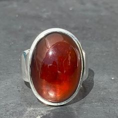 Oval cabochon garnet ring adjustable  set in sterling silver, handmade and fair trade Natural Garnet without any treatmentSetting - Double frame  Crystal Family - Silicate mineral Stone origin - IndiaHardness - 6-7.5Metal - 925 sterling silver Stone size - L 2.1 x B 1.6 x H 0.7 cmL 0.85 x B 0.65 x H 0.3 inchRing size - U.K - OU.S - 7EU - 14 / 54Adjustable - yes, open on the top so doesn't pinch the finger or catch stuff Band width - 0.9 - 0.5 cmWeight-11.6 gramsHealing properties - mental & Large Garnet Ring, Bloodstone Ring, Blue Aquamarine Ring, Star Garnet, Silicate Minerals, Double Frame, Tourmalinated Quartz, Tourmaline Pendant, Garnet Ring