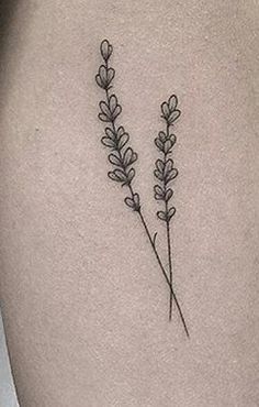 a tattoo on the back of a woman's stomach with two flowers growing out of it