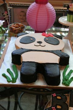 there is a cake that looks like a panda bear on the table with other decorations