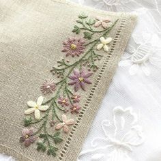 a close up of a piece of cloth with flowers embroidered on the front and back