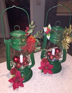 two green lanterns with christmas decorations on them