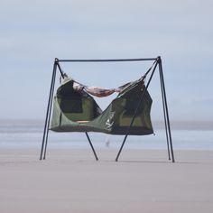 an empty chair sitting on top of a sandy beach