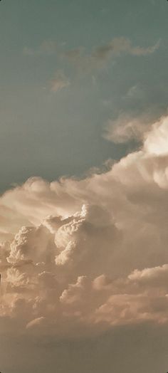 an airplane is flying high in the sky with clouds behind it and another plane on the ground