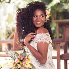 a woman with long curly hair and flowers in her hair is posing for a photo