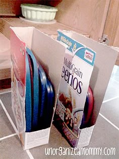 there are several pieces of luggage in the box on the kitchen floor, and one is empty