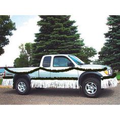 a truck decorated with fringes and trees in the background