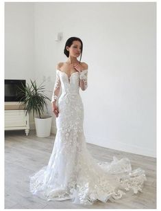 a woman in a white wedding dress posing for the camera with her hands on her hips