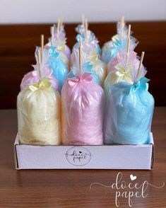 a box filled with lots of different colored lollipops on top of a wooden table