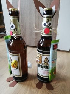 two beer bottles decorated to look like animals with faces on them and ears sticking out