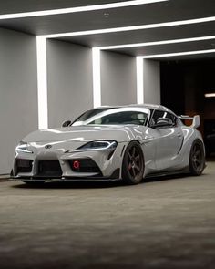 a white sports car parked in a parking garage