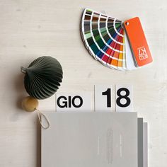 there is a pantone book and some other items on the table next to it