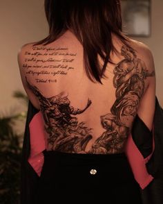 the back of a woman's body with tattoos on it