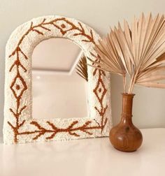 a decorative mirror and vase on a table