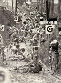 an old black and white photo of people riding bikes down a street with signs in the background