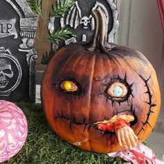 two carved pumpkins sitting on top of green grass