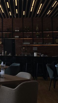 an empty restaurant with tables and chairs in front of brick walls, lighting up the room