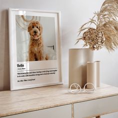 a dog sitting on top of a table next to a vase