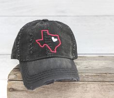 "Need to change this cap design to a messy bun/high ponytail cap style, a non-distressed baseball cap or kid's baseball cap? Once you have this cap in your cart, head here: https://etsy.me/2S82fka Distinct Headwear Presents... Texas Embroidered Cap with Heart Accent. Choose your cap color, TX color, optional heart color and heart location. Shown on: dark grey base with a white heart and pink outline. black base with a white heart and a magenta outline. Purchase as shown or choose your own custom Black Distressed Dad Hat One Size, Adjustable Distressed Black Dad Hat, Trendy Distressed Dad Hat, Casual Adjustable Baseball Cap As Gift, Distressed Trucker Hat For Baseball Season, Casual Dad Hat As Gift, Casual One Size Fits Most Dad Hat As Gift, Casual Snapback Hat With Curved Bill For Gift, Casual Snapback Hat With Curved Bill As Gift