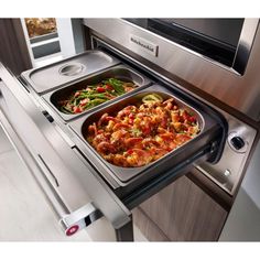 two pans filled with food sitting on top of an oven door open to the side