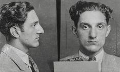 two men in suits and ties are mugshots, one is holding a sign