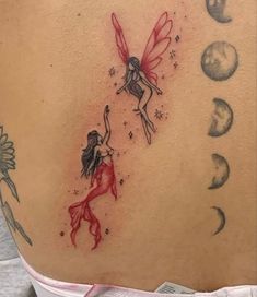 a woman's back with a tattoo on it that has two fairy tinkerbells flying over the moon and stars