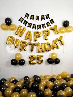 black and gold balloons are in front of the happy birthday sign