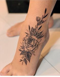 a black and white rose tattoo on the foot