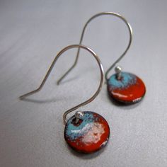 "Simple little circles of glass enamel, bright red shading into robin's egg blue, suspended by a handcrafted sterling silver ear hook with a ball finial. Charmingly simple and good colorful fun, an everyday style that you can dress up or down. The powdered glass enamel is kiln-fired onto both sides of the copper discs, so there is no exposed metal. The circles measure 3/8\" or 10mm in diameter. The overall length of the earrings is 7/8\" long, including the hand crafted sterling silver hooks. I