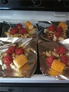 three foil packets filled with food sitting on top of an oven