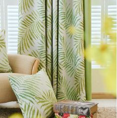 a living room scene with focus on the curtains and pillows in front of the window