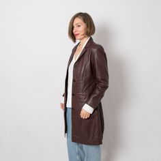 "90s Burgundy Leather Jacket with belt originally womenswear. Surface, Very Good Condition, no damages. we suggest S Size but please see measures below. Very Unique Gift for an Anniversary, Christmas, Birthday. Stunning Quality piece. m e a s u r e m e n t s (taken while item is lying flat): shoulder: 15.7″/ 40 cm, around armpits: 36.2\"/ 92 cm, waist: 32.3\"/ 82 cm, hips: 33.8\"/ 86 cm, sleeve length: 23.6\"/ 60 cm, length: 37.8″/ 96 cm Model is 170 cm or 5.5 feet tall, size M, but wears all si Dark Red Leather Jacket, Leather Jacket With Belt, 90s Leather Jacket, Leather Jacket Long, Burgundy Leather Jacket, Jacket Buttons, Albania, Timeless Classic, Christmas Birthday